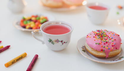 holiday, birthday party composition with colorful pink glazed donuts on white table, flatlay top view