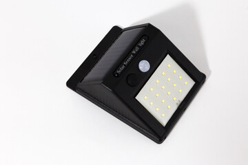 
Solar-powered wireless light. A modern and economical type of street lighting. Convenient wall lamp. The lantern is powered by solar panels. White background.