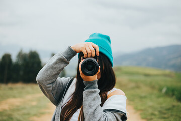 Fototapeta premium Joven fotógrafa mujer en una montaña. Concepto de Personas y Tecnología, Turismo.