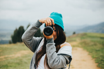 Fototapeta premium Joven fotógrafa mujer en una montaña. Concepto de Personas y Tecnología, Turismo.