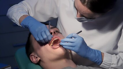 Caucasian female dental nurse examining teeth of male patient at modern dental clinic. healthcare and dentistry business.
