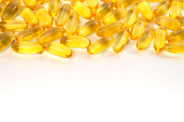 Yellow omega 3 capsules on the from above of a white background.  Header, footer and running title for a website, banner, post or other promotional product. Close-up, top view, free space for text.