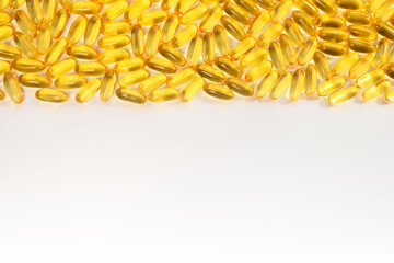 Yellow omega 3 capsules on the from above of a white background.  Header, footer and running title for a website, banner, post or other promotional product. Close-up, top view, free space for text.