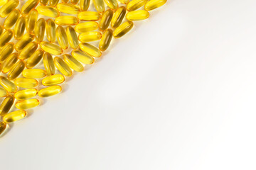 Group of omega 3 capsules forming angular white background. Close up of big gel translucent golden...