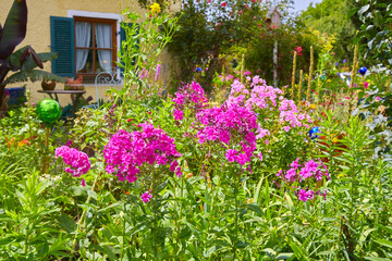 Beautifully maintained farmhouse garden with colorful flowers, in Bavaria, Southern Germany.