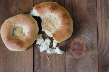 uzbek flatbread white bread is broken into pieces crumbs on a brown background illustration
