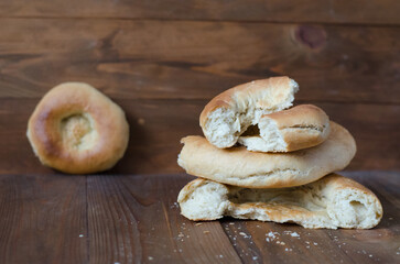 uzbek flatbread white bread is broken into pieces crumbs on a brown background illustration