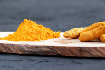 Turmeric curcurmin powder spice and dried root of turmeric on a wooden background. Vegan and healthy food. Organic food.Curcuma powder