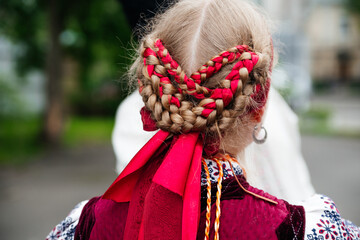Fototapeta na wymiar Ukrainian woman with braided hair in ribbons braids Elements of Ukraine traditional national costume