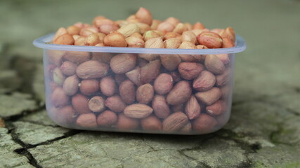 Salted Roasted Peanuts, Peeled raw peanuts are in a plastic cup, Healthy content, Copy space, top view.