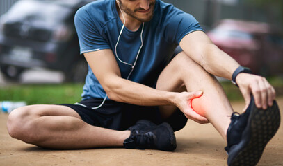 This injury calls for a timeout. Shot of a sporty young man holding his calf in pain while exercising outdoors.