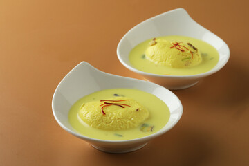 Rasmalai is an Indian dessert sweet with dry fruits and Saffron toppings, served in a bowl . selective focus