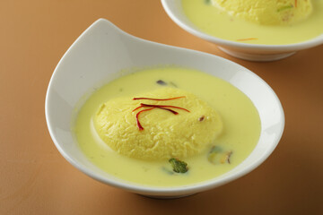 Rasmalai is an Indian dessert sweet with dry fruits and Saffron toppings, served in a bowl . selective focus