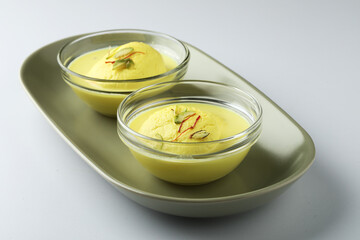 Rasmalai is an Indian dessert sweet with dry fruits and Saffron toppings, served in a bowl . selective focus