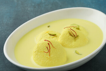 Rasmalai is an Indian dessert sweet with dry fruits and Saffron toppings, served in a bowl . selective focus