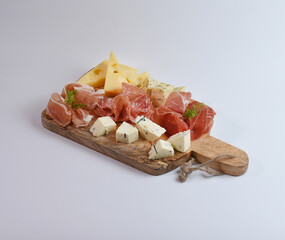 Appetizers table with different antipasti, charcuterie, snacks and cheese. Buffet party. Wooden cutting board isolated on white background, top view