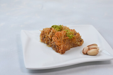 Traditional arabic and turkish sweets pastry dessert kadaif with pistachio. 