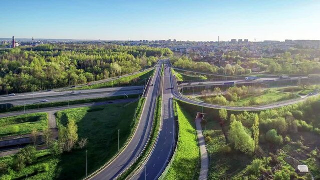 Highway multilevel crossing. Spaghetti junction on A4 international motorway, the part of freeway around Krakow, Poland. Aerial 4K approaching/panning video 