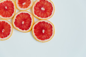 Grapefruit slices on the white background. Top view. Minimal colourful trend style. Copy space. Cut...