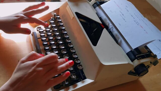 girls with red nail polish writing with antique typewriter