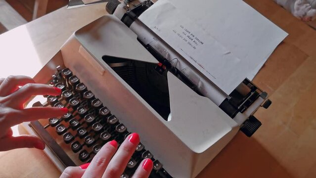 girls with red nail polish writing with antique typewriter