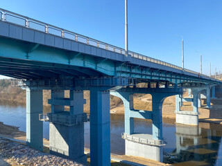 Fototapeta na wymiar A road bridge over the river. Structures of the automobile bridge from below