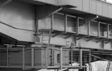 A road bridge over the river. Structures of the automobile bridge from below. Black and white photo