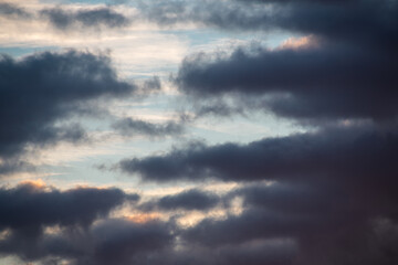 Fototapeta na wymiar Tiefdunkelblaue Wolken vor blauem Morgenhimmel