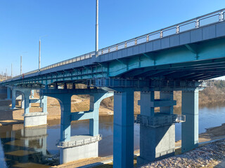 A road bridge over the river. Structures of the automobile bridge from below