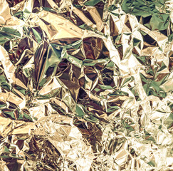 Silver yellow green crumpled foil metallic luster texture background
