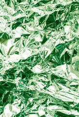 Silver green crumpled foil metallic luster texture background
