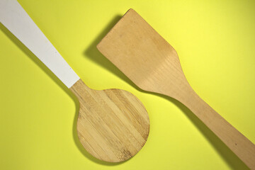 Two kitchen spatulas. On a yellow background.