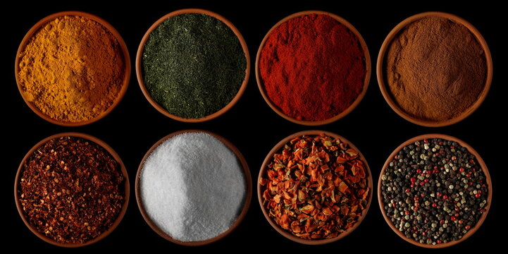Set spices, turmeric powder, dry chopped dill, red paprika, cinnamon ground, spicy chili pepper flakes, sea ​​salt, dry chopped carrot pieces, colorful mixed pepper grains isolated on black 