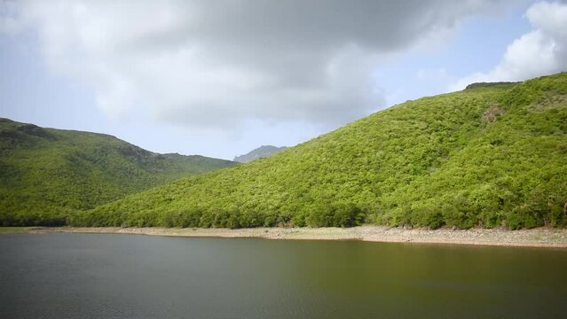 Willingdon Dam filled with water and lush green Girnar mountain on background at Junagadh, Gujarat, India. Beautiful nature during monsoon season. Monsoon landscape. 