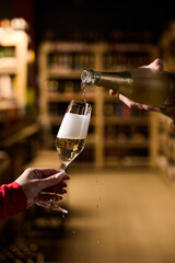 The girl holds a glass in which champagne is poured