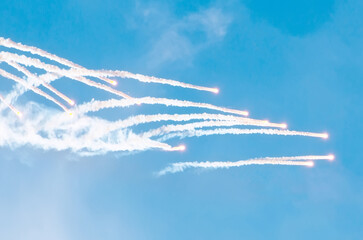 Launching rockets from the ground and burning in the sky.