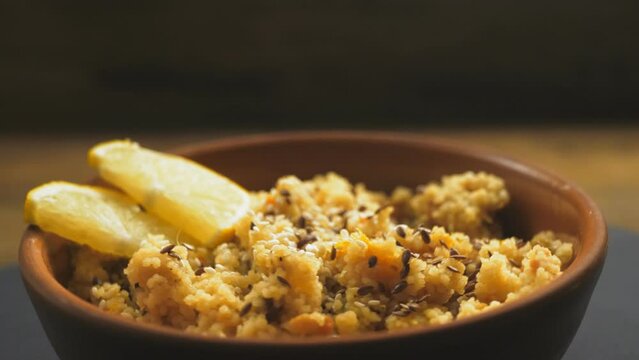 Couscous masfouf with dried fruits and sesame nuts in a coconut shell plate