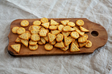 Homemade Salty Crackers on a Rustic Wooden Board, side view.