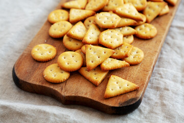 Homemade Salty Crackers on a Rustic Wooden Board, low angle view.
