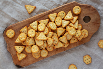 Homemade Salty Crackers on a Rustic Wooden Board, top view. Flat lay, overhead, from above.