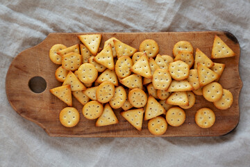 Homemade Salty Crackers on a Rustic Wooden Board, top view. Flat lay, overhead, from above.