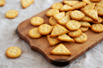 Homemade Salty Crackers on a Rustic Wooden Board, side view.