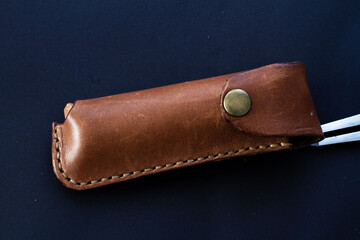 Leather knife sheath with the black background. Leathercraft tools