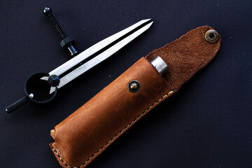 Leather knife sheath with a black background. Leathercraft tools