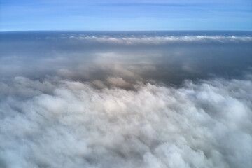 Aerial view from high altitude of earth covered with puffy rainy clouds forming before rainstorm