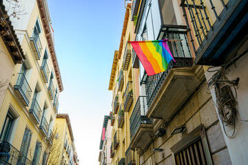 Facade of the Chueca neighborhood in the city of Madrid with a rainbow flag representing homosexual pride and the defense of LGTBI rights - obrazy, fototapety, plakaty