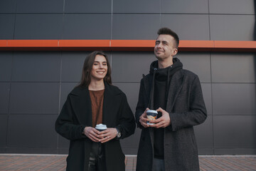 Young loving couple with coffee on black industrial background