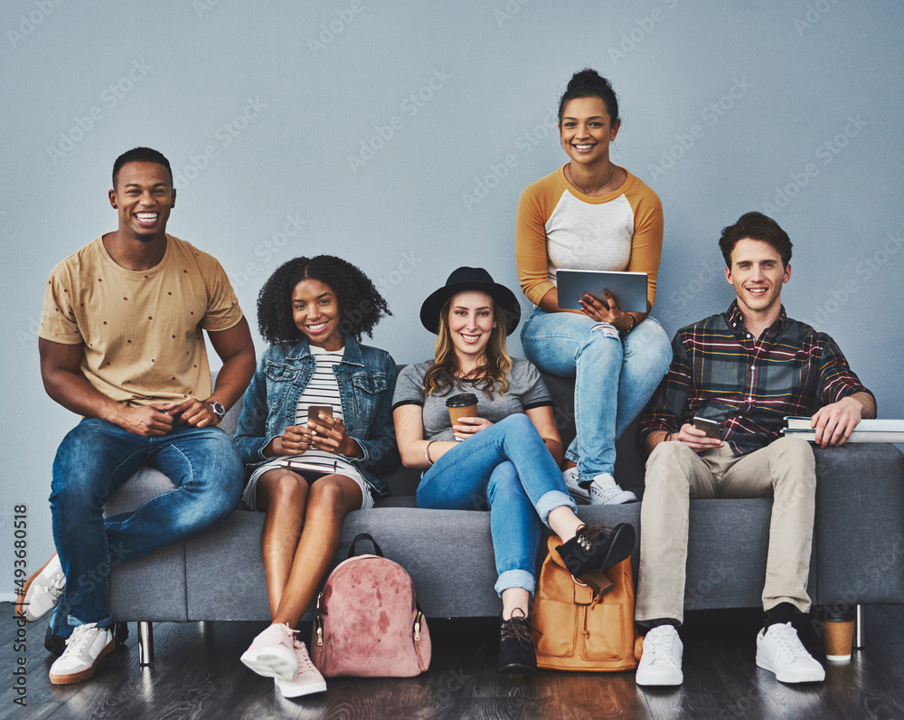 Aufkleber The age of the social media movement. Studio shot of young people sitting on a sofa and using wireless technology against a gray background.