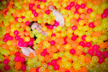 portrait of a teenage girl in multi-colored balls.