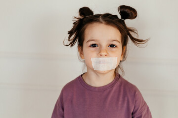 Child with adhesive tape on her mouth. Censorship is connected to children and youth